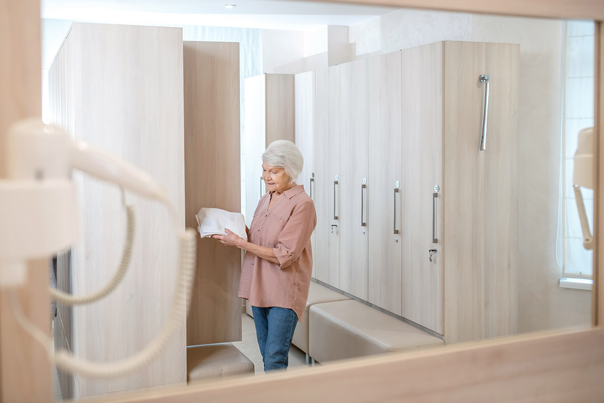 Gray-haired mature woman in a changing room in spa center